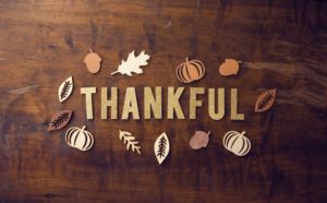 Thankful spelled out on a table with autumn leaves