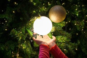 girl with hands under a glowing ornament
