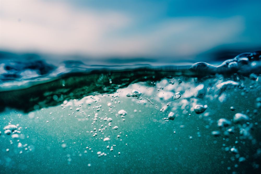 photo half under ocean water with bubbles