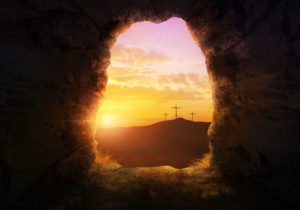 Empty tomb with three crosses on a hill side.