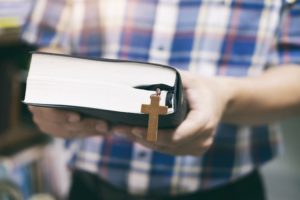 Religion Christianity concept. Man holding and reading the holy Christian Bible