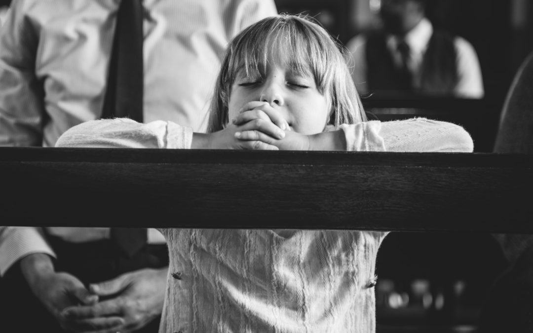 child praying in church