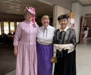 Three lovely women dressed in late 19th/early 20th century period costume, celebrating Heart of Longmont's 150th anniversary.