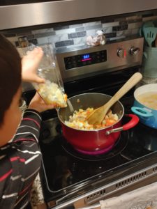 A young chef cooking a Chef Hearty meal