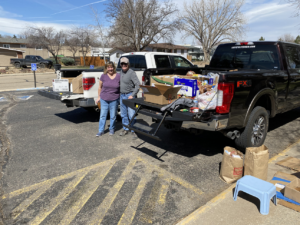 HOL members standing with two trucks full of donations for the OUR Center