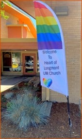 Photo of HOL's new feather flag with rainbow colours, welcome message, and logo
