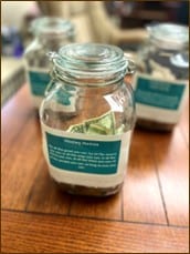 Photo of jars labeled with the proposed Housing Project names with money inside