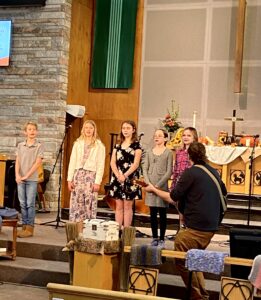 A photo of the Joyful Noise Youth and Children Choir performing during worship service