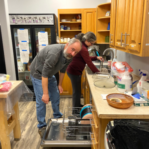 Volunteers clean up and load the dishwasher after serving dinner at HOPE