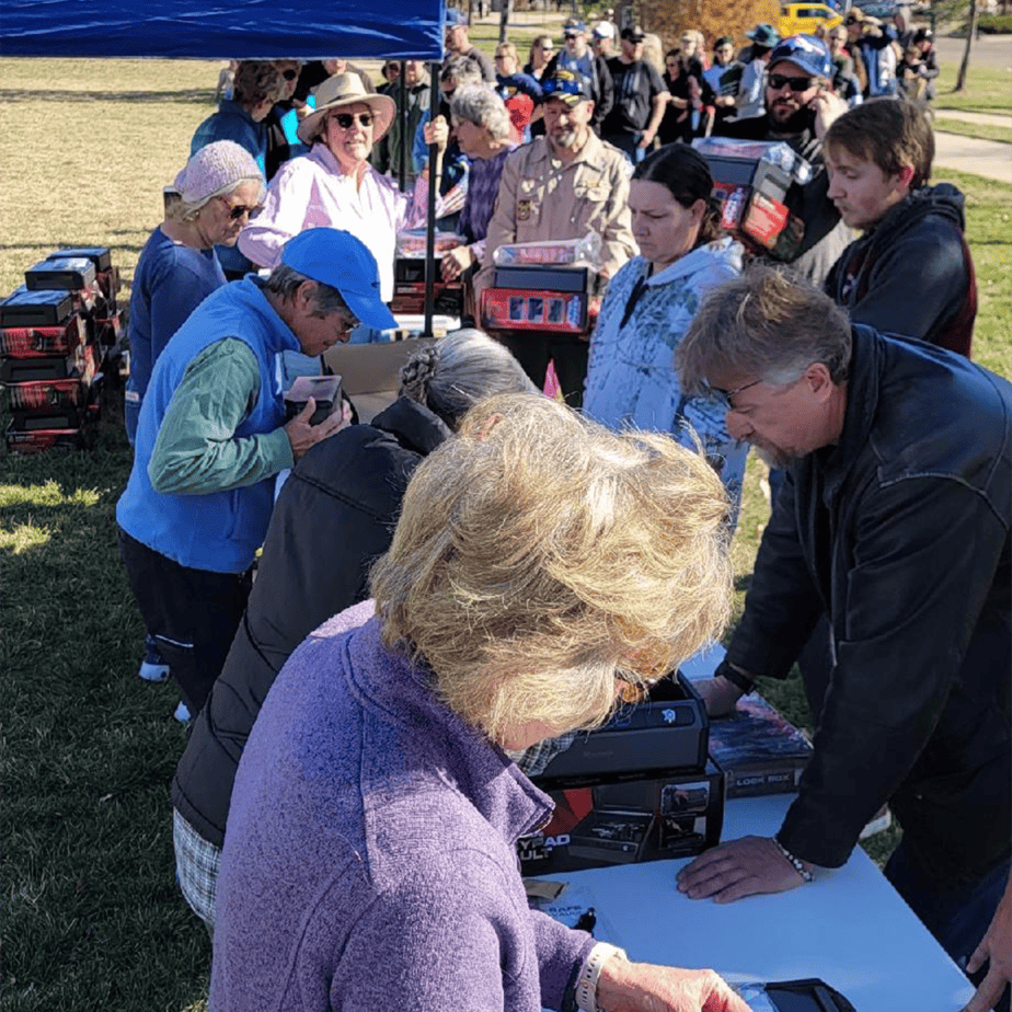 a line of volunteers and members of the community at the veteran's day gun safe giveaway 2023